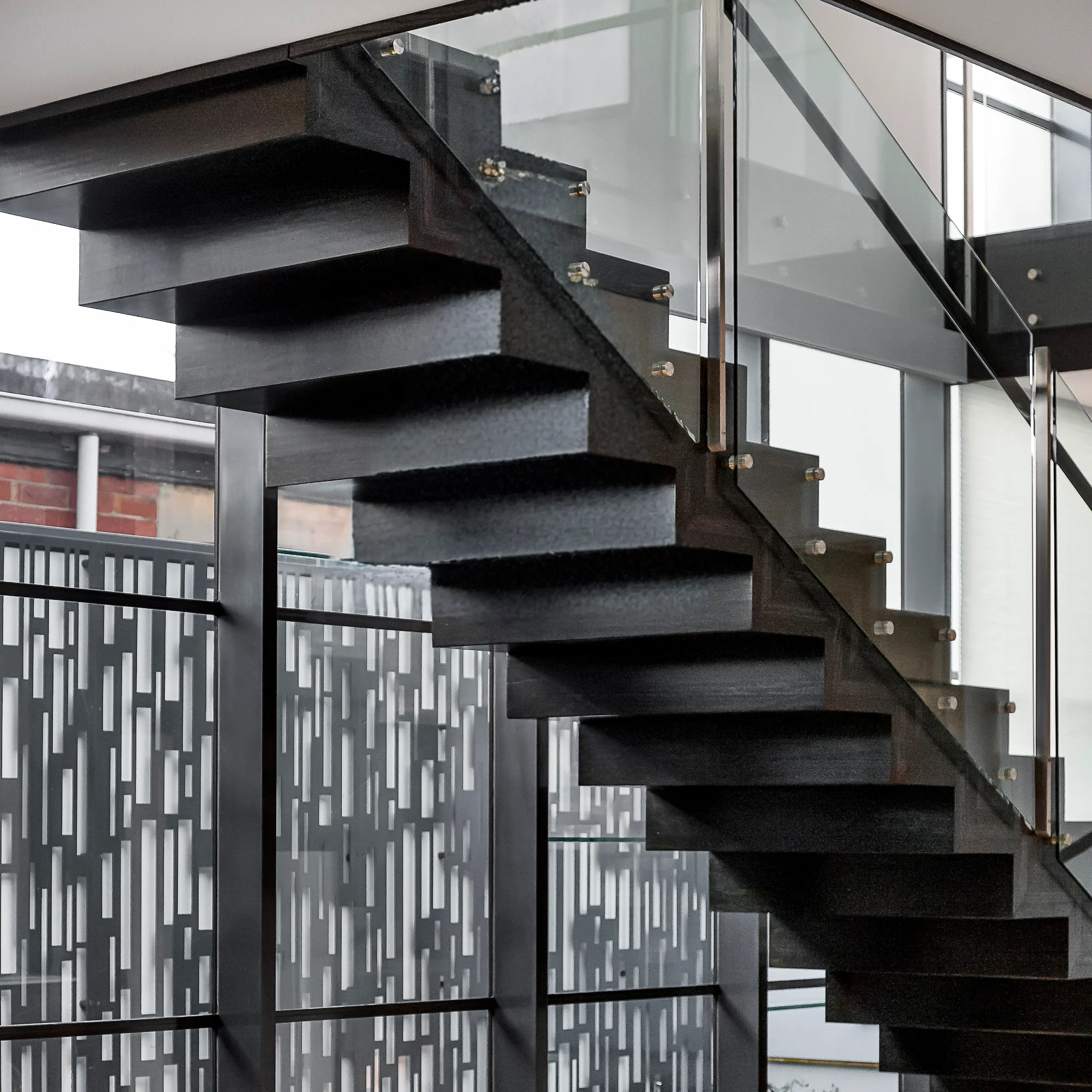 A striking straight staircase with a black metal frame